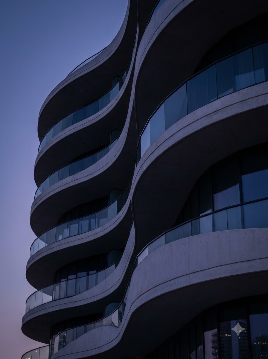 Apartment building with flowing curved balconies at twilight
